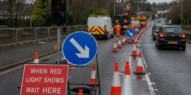 Roadwork with traffic signs and cones on a street.