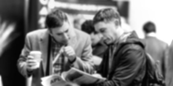 two gentlemen reviewing document over coffee