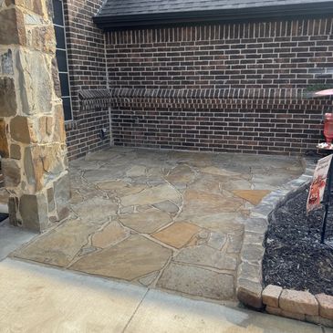 Stone patio corner with brick and stone walls.