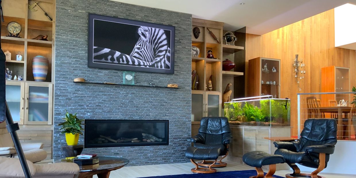 Fireplace wall in the living room of this modern condo remodel with the atrium in the background