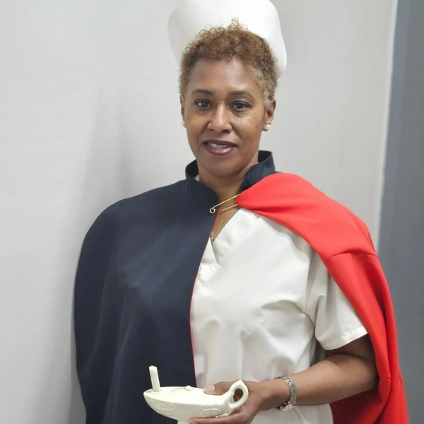 nurse with cap and cape holding a candle lamp
