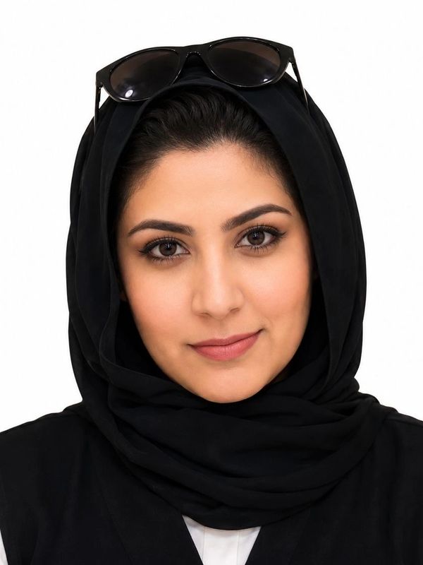 Portrait of a woman wearing a black hijab and sunglasses on her head.