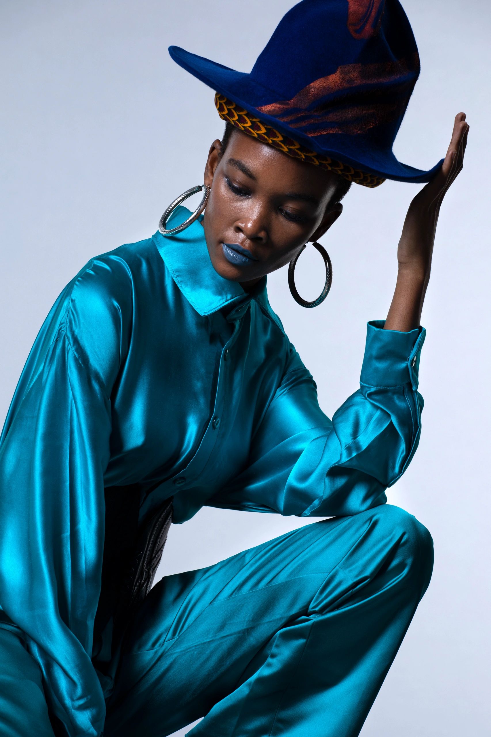 Model wearing blue outfit and blue hat 