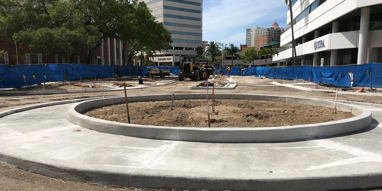 Construction site with a roundabout being built in an urban area.