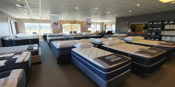 Mattress store interior with rows of beds and bedding