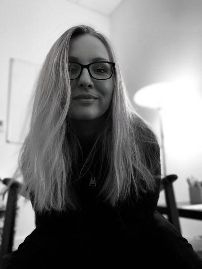 Black and white portrait of a woman wearing glasses.
