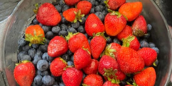 Fresh strawberries and blueberries in a bowl.