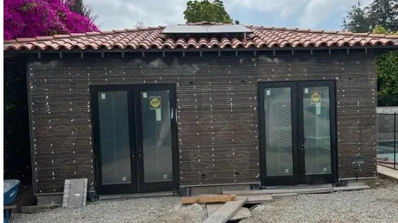 A small building under construction with solar panels on the roof.