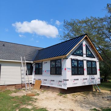 New house construction with siding and windows under a blue sky.