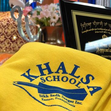 Khalsa School yellow fabric with plaque in the background.
