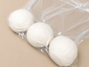 Three white dough balls in a clear plastic bag.