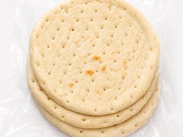 Three packaged pizza crusts in clear plastic.