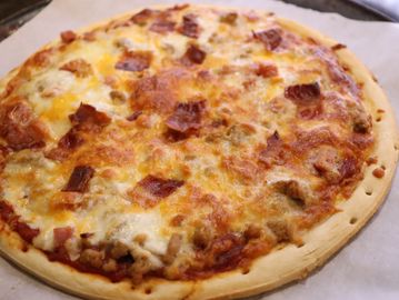 Homemade pizza with cheese and meat topping.
