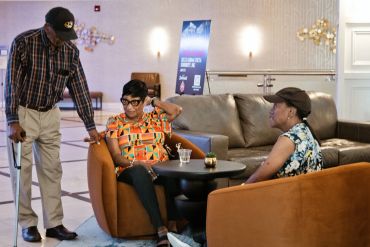 Three people talking in a lounge area.