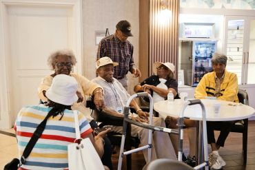 Group of elderly people socializing indoors.