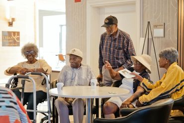 Elderly people socializing indoors at a community space.