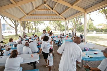 People gathering under a pavilion for an outdoor event.