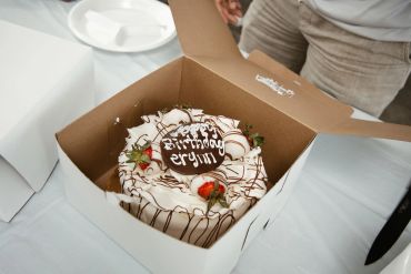Birthday cake in a box with strawberries and chocolate.