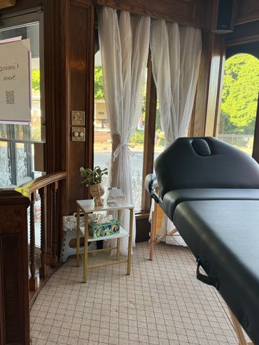 Tranquil wellness treatment room with a massage table and natural lighting.