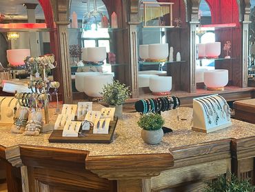 Elegant display of healing crystals, jewelry, and singing bowls at Alchemy Wellness.