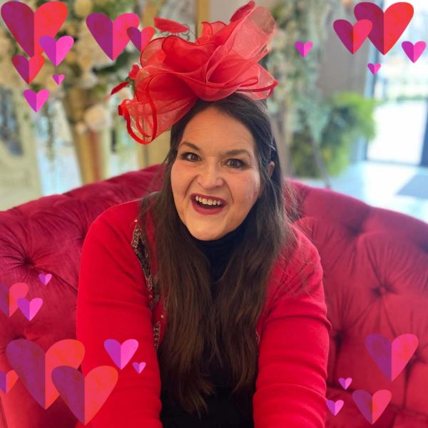 Woman in red with joyful expression and heart decorations.