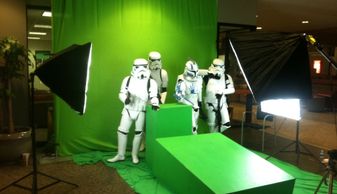 Stormtroopers posing in front of a green screen with studio lights.