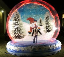 Person inside a large inflatable snow globe with a snowman.