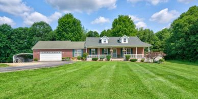 Large brick house with a grassy front yard.