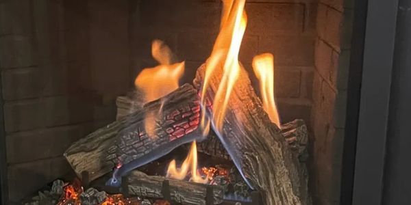 A cozy fireplace with burning logs and glowing embers.