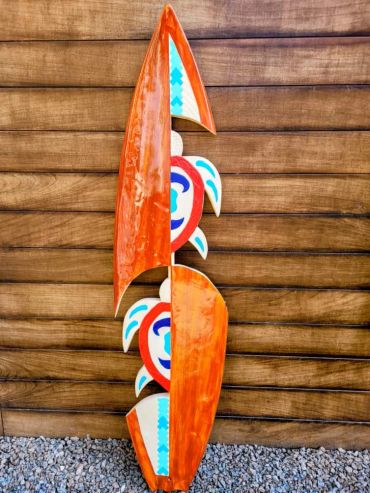 Colorful wooden surfboard art with turtle motifs.