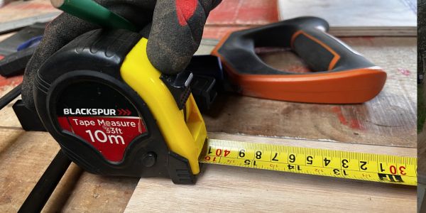 Tape measure being used on wood.