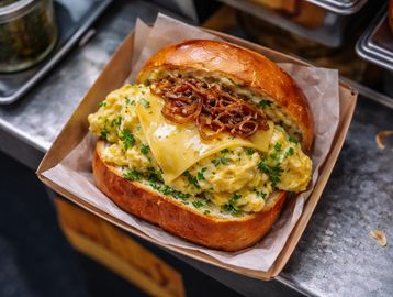 Fluffy scrambled egg with herbs, cheese, caramelised onions on brioche. Herby, creamy, satisfying.