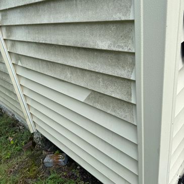 Side of a house with dirty and clean siding sections.