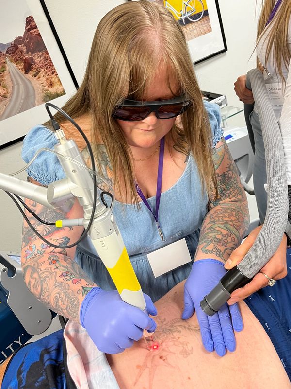 Owner, Amy Green, is performing a laser treatment on a client.