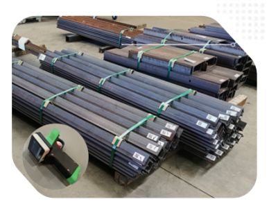 Stacked metal square tubes tied with green straps.