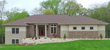 Transitional hip roof ranch home with side load garage.