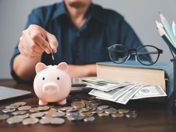 A man putting coin inside a piggies bank