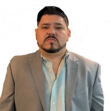 Man in a gray blazer and light blue shirt with a serious expression.