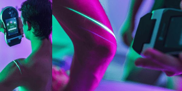 Person using a device with neon lighting highlighting their shoulder and knee.