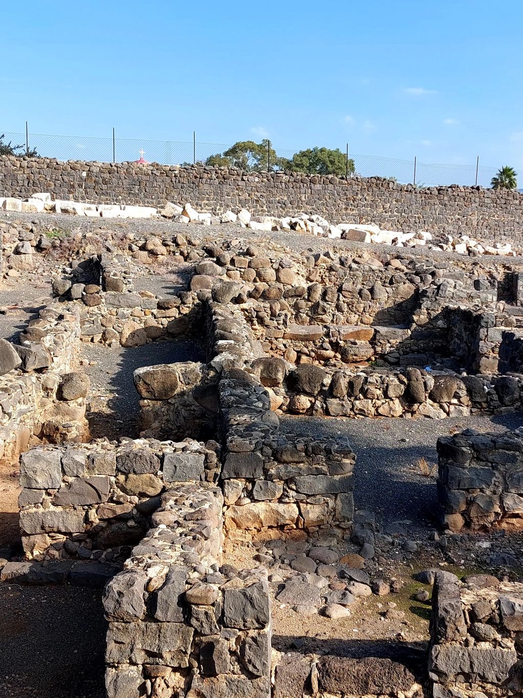 Ruins of an ancient stone settlement under a clear blue sky.