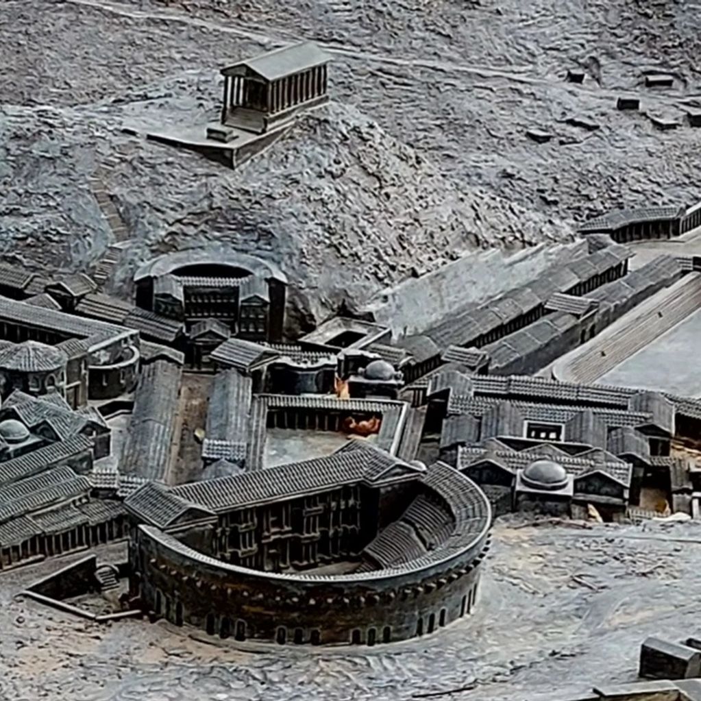 A detailed model of an ancient Roman city with amphitheater and temples.
