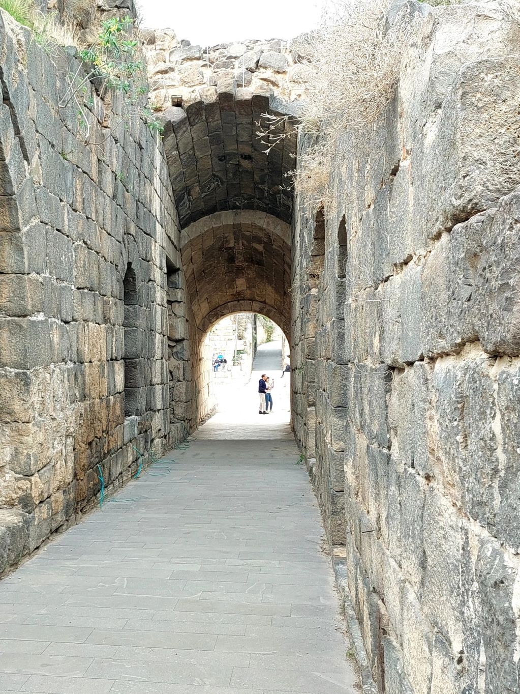 Ancient stone corridor with arched ceilings and narrow walkway.
