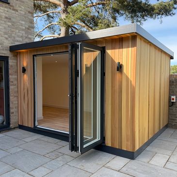 Modern garden office with wooden exterior and glass doors.