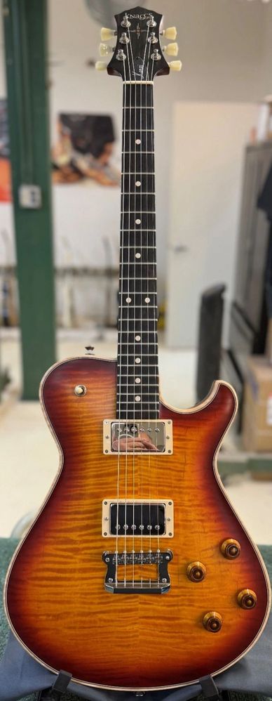 A sunburst electric guitar with dual humbucker pickups and wooden knobs.