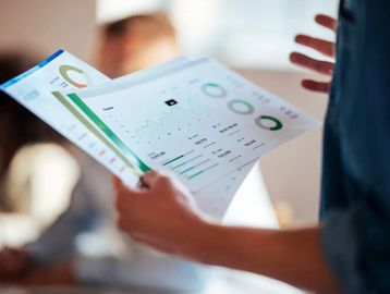 mujer sostiene documentos de un informe empresarial