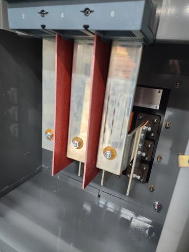 Close-up of electrical busbars inside a metal panel.