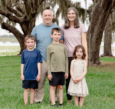 Family portrait outdoors with three children and two adults.