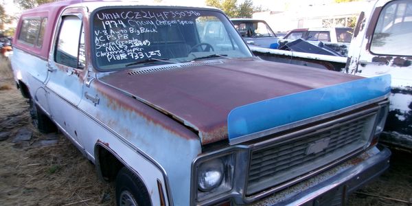 1974 Chevrolet truck with rusted hood and details written on windshield.