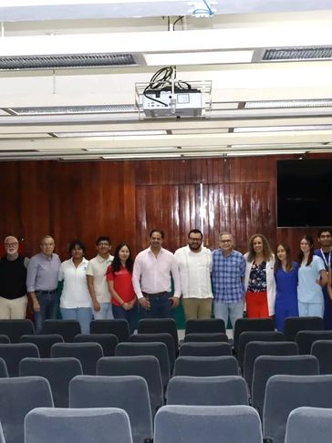 Group photo of people standing in a lecture hall with rows of seats.