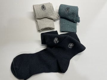 three pair of socks with three initials monogrammed on each